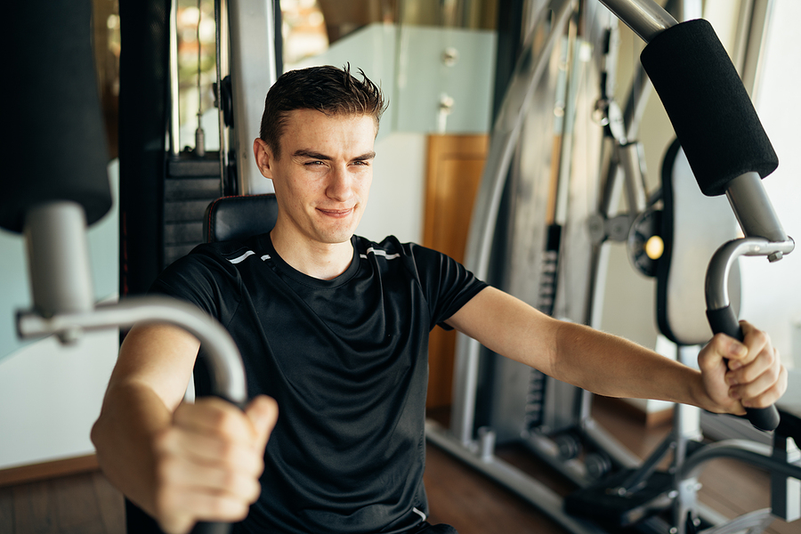 Young man doing fitness exercises on home gym